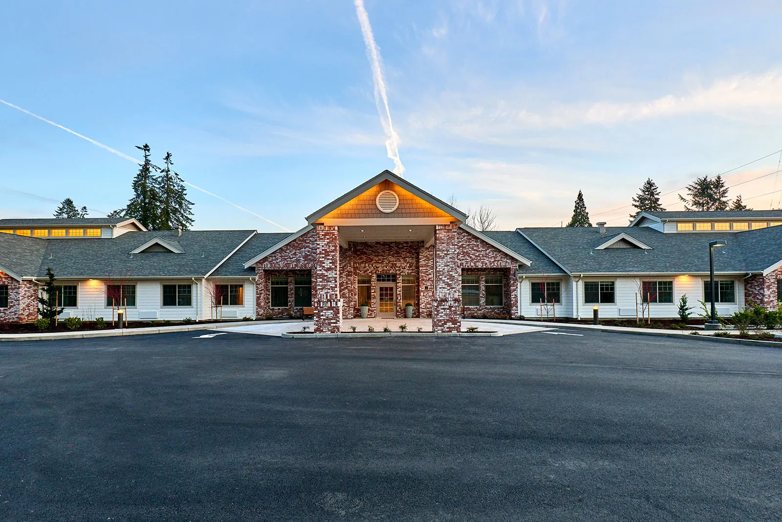 Brick community building with central entrance at dusk
