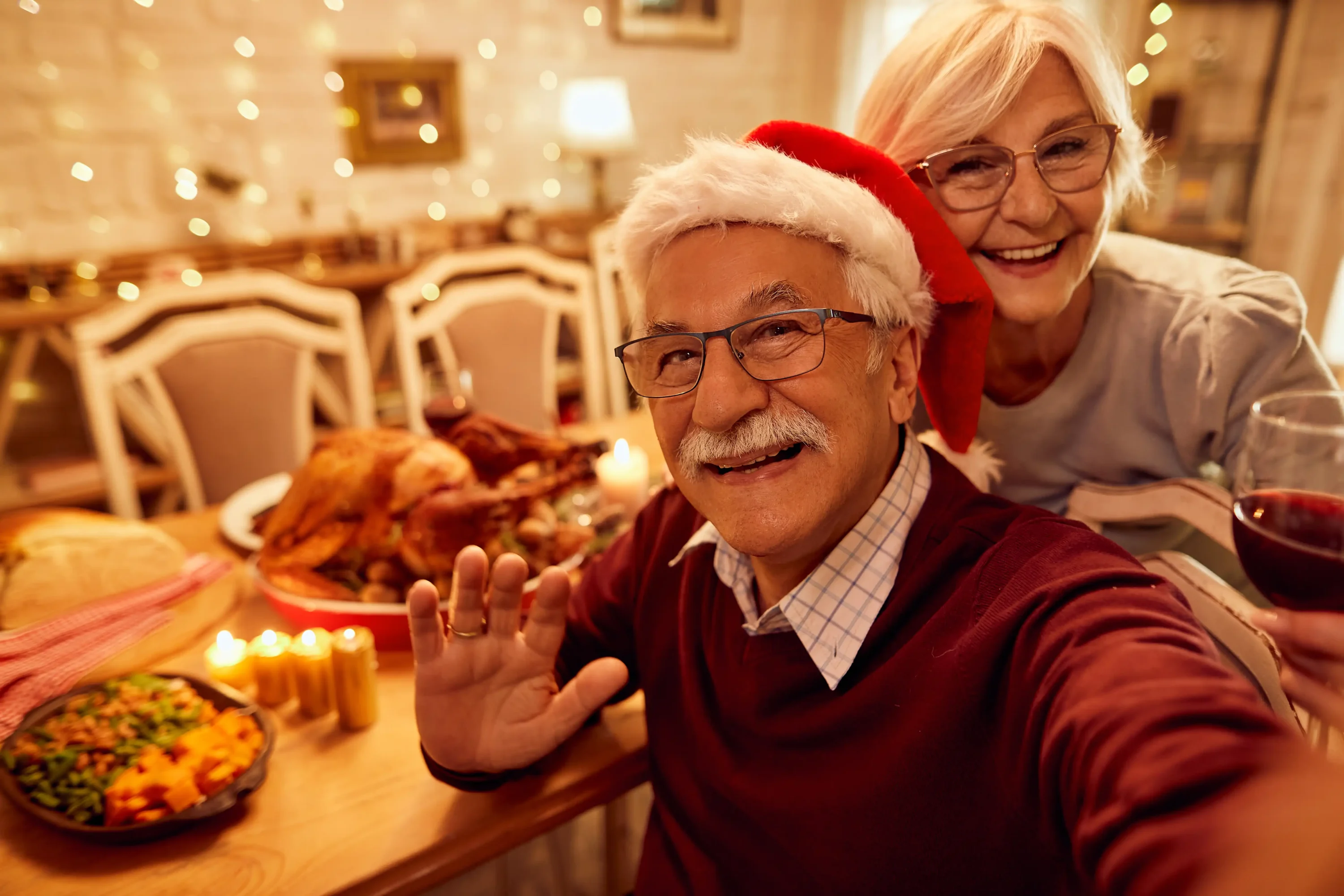 Elderly couple taking festive holiday dinner selfie