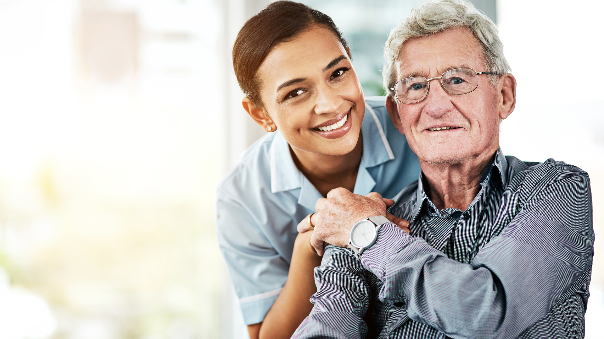Smiling caregiver with elderly man indoors
