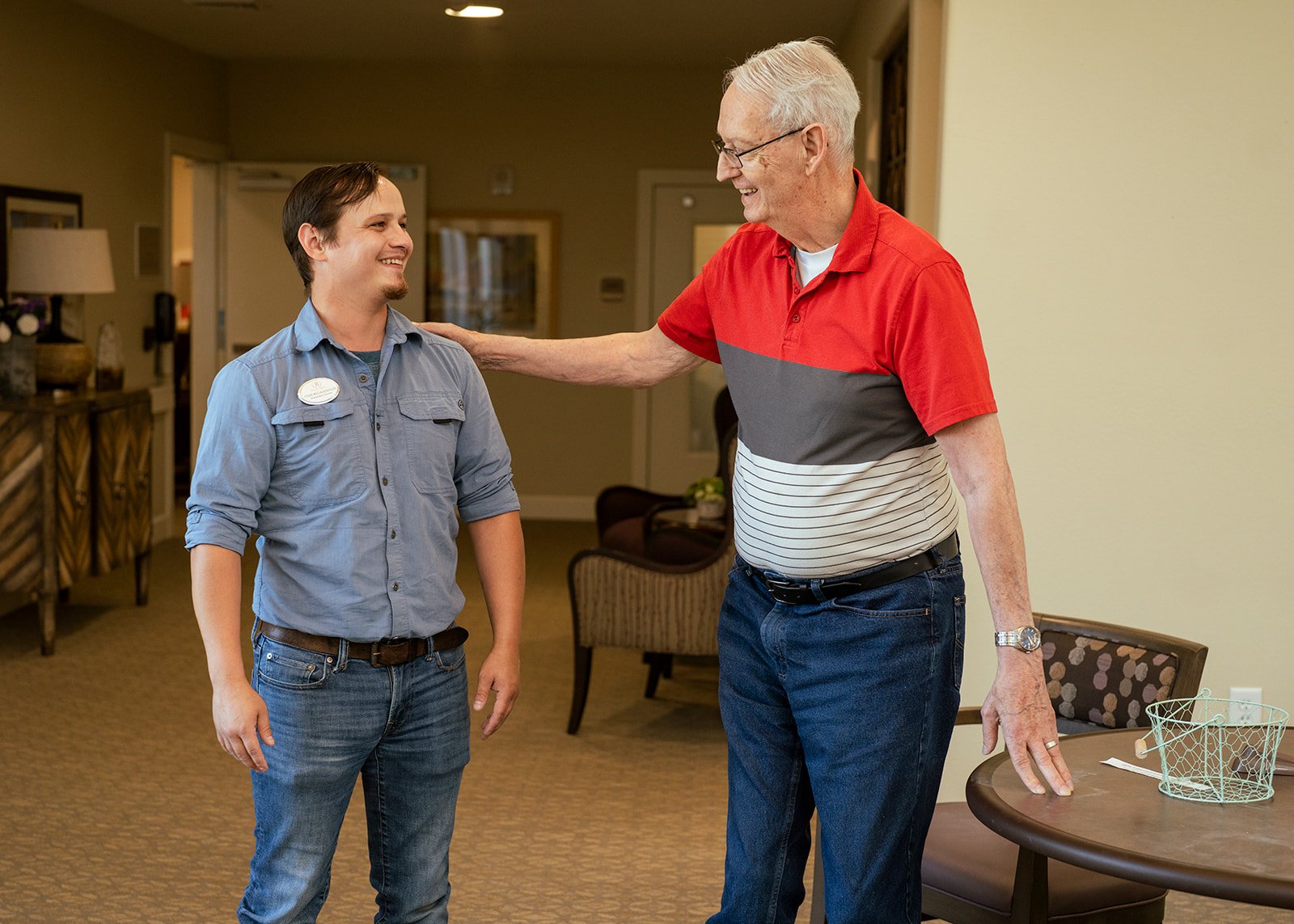 Elderly man smiling with caregiver indoors